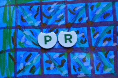 mavi arkaplandaki renkli harflerden yapılmış halkla ilişkiler sözcüğü.