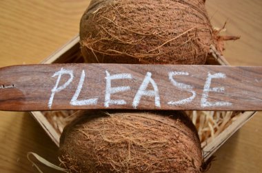 Hindistan cevizi ve üzerinde yazı olan tahta bir tabela.