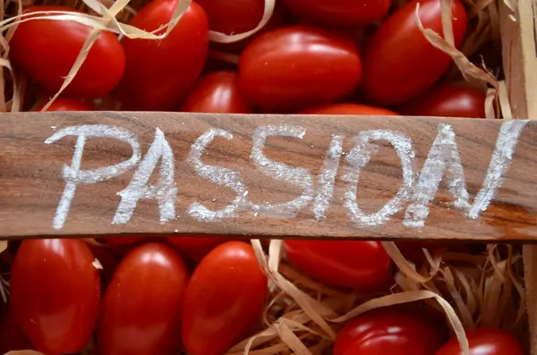 Aşk sözcüğü ahşap bir arka planda kırmızı harflerle yazılmış.