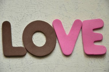 Tahta arka planda renkli harflerle aşk kelimesi..