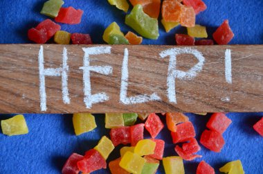 Beyaz arkaplanda kelime yardımı ile renkli şekerler