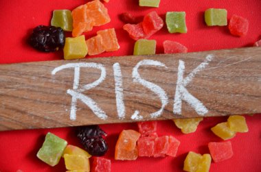 Tahta masada kelime şeker ve kelime riski içeren renkli küpler.