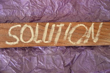 Kelime yazmak işe çözüm getirir. Çözüm için iş kavramı, zor bir durumu iyileştirmeye yardımcı olur. Tahta karton parçasına yazılmıştır.
