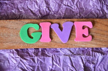 Soyut renkli arkaplanda hayırseverlik yazıyor.