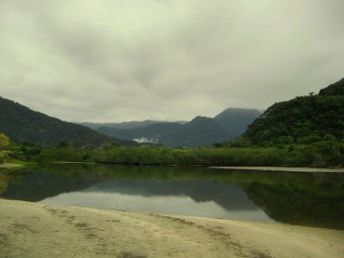 Arkasında dağlar olan bir nehir manzarası. Ubatuba, Sao Paulo. Brezilya