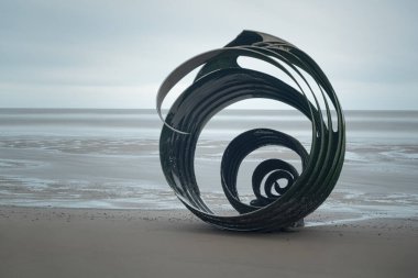 İngiltere, Lancashire, 23 Kasım: Lancashire sahilinde gelgitler ve zamanla şekillenen metal kabuk heykel.