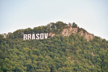Brasov, Romanya - Ağustos 2019: Brasov, Romanya 'nın Brasov kentindeki bir orman yamacındaki ikonik Brasov imzası Hollywood tabelasını anımsatıyor.