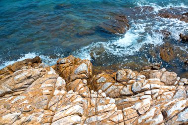 Kayaların ve deniz suyunun renkli desenleri.