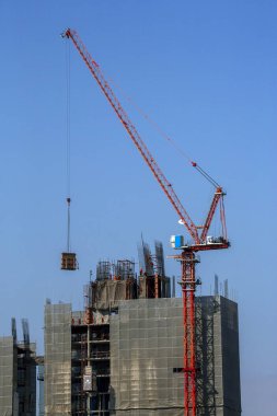 Mavi gökyüzüne karşı vinç ve inşaat alanı