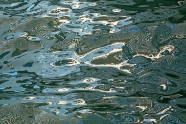 Su yüzeyindeki renkli soyut desenler.