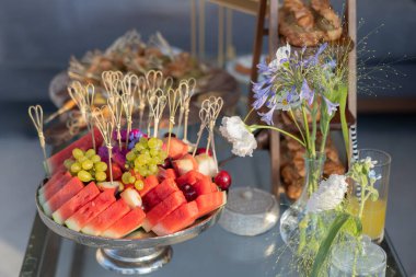 Renkli Taze Meyveler ve Çiçek Düzenlemeleri Zarif Masada, Yaz Toplantısı ya da Kutlama İçin Mükemmel