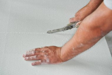 Polistiren köpük ısı yalıtımı kesen adam eski çekilebilir alet bıçağıyla, yakın çekim detaylarıyla.