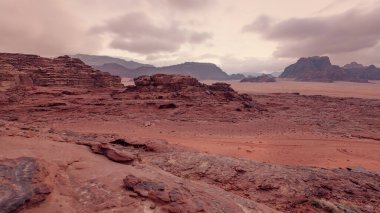 Kırmızı turuncu Mars, Ürdün Wadi Rum Çölü 'ndeki manzara gibi. Dağların arka planı, bulutlu bir sabah. Bu konum birçok bilim kurgu filminde kullanılmıştır..