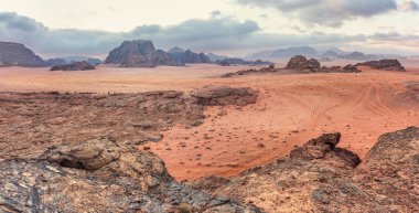 Sabahları Wadi Rum çölündeki Rocky manzarası, uzaktan görülebilen küçük kamp çadırları..