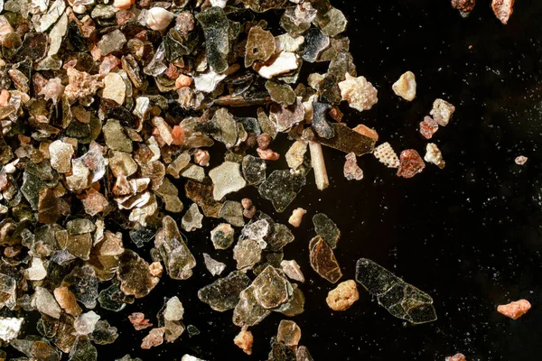 Mořský Písek Zlatavými Částicemi Černém Pozadí Zvětšovací Mikroskop Fotografie Zbývá — Stock fotografie