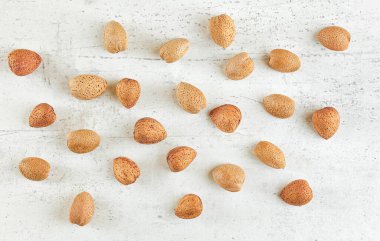 Yukarıdan aşağıya doğru, beyaz taş tahtada badem kabuğu var.