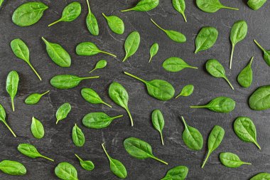 Mısır salatası (Valerianella locusta) siyah tahta üzerine dizilmiş yapraklar - yukarıdan çekim gibi. Sağlıklı yeşil yaprak besin kavramı