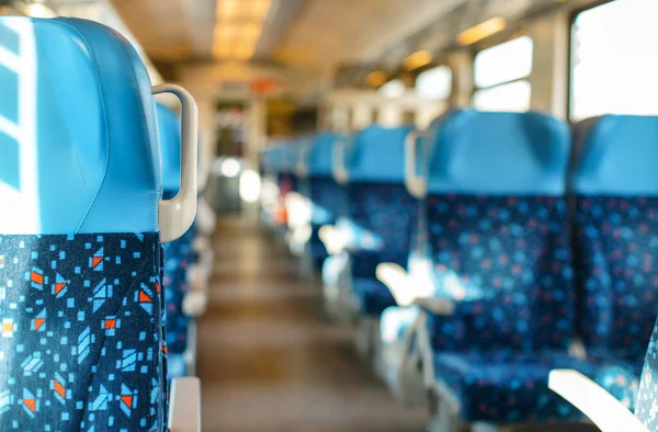 Sun shines on empty seats in train, abstract rail travel concept with shallow depth of field photo only close chair focus