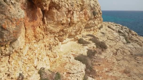 Okyanus Kıyısındaki Kayaların Yanında Yürümek Uzak Mesafedeki Sakin Deniz — Stok video