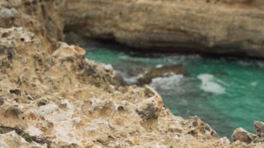 Kayalık körfez açık yeşil su ile tepeden görünür, odak ön plandan mesafeye hareket eder, tipik Mallorca manzarası Ansa de s Estri 'de