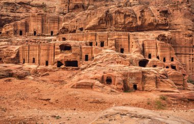 Petra, Ürdün 'de görüldüğü gibi basit harabeler - taş duvardaki delikler gibi mağaralar -