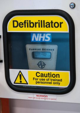 Londra, Birleşik Krallık - 05 Şubat 2019: Otomatik dış defibrilatör kutusunda açık sarı uyarı işareti, alışveriş merkezi duvarına yerleştirilmiş, kapatma ayrıntısı