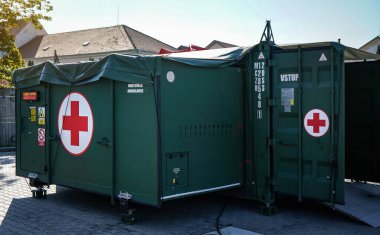 Brno, Çek Cumhuriyeti - 08 Ekim 2021: Kızıl haçlı yeşil metal ordu konteynır kutuları, IDET askeri ve savunma fuarı sırasında saha ambulansı gösterisi olarak kuruldu