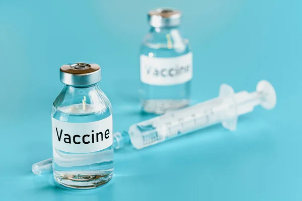ワクチン瓶バイアルともに低血圧注射針付近シアン背景 — ストック写真