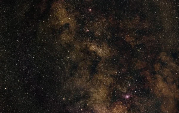 靠近Scutum和Sagittarius星座的有银河的夜空 明亮的M22球状星团左侧 紫色的泻湖和Trifid星云可见 长期曝光堆放的照片 — 图库照片