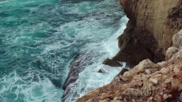 岩石海岸上的海难 绿水飞溅 形成白色泡沫 从上方看 慢镜头 — 图库视频影像
