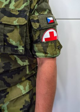 Brno, Çek Cumhuriyeti - 08 Ekim 2021: Kızıl haç işareti ve modern üniformalı asker kolunda Çek bayrağı, yakın çekim ayrıntıları