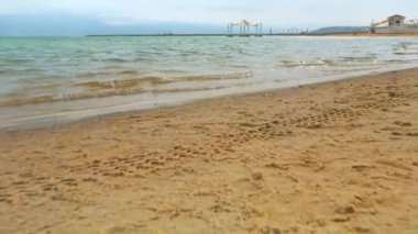 Güneşli bir günde, kumlu sahilde denize yürümek - Ein Bokek, İsrail 'de ölü bir deniz tatil köyü