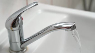 Krom gümüşü musluk su akışı, yakın çekim detayı