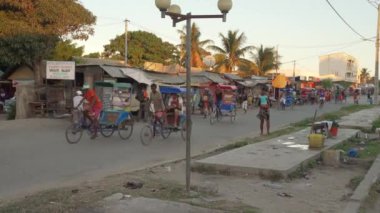 Toliara, Madagaskar - 01 Mayıs 2019: Meşgul kavşakta tipik bir akşam manzarası, insanlar yürüyor, bisiklet arabası geçiyor, piyasa duraklıyor