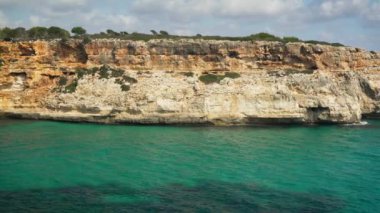 Açık mavi deniz suyu, kayalık uçurumlar... Calo Antena, Mallorca 'da güneşli bir gün.