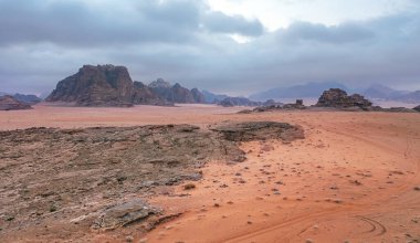 Kırmızı turuncu Mars, Ürdün Wadi Rum Çölü 'ndeki manzara gibi. Dağların arka planı, bulutlu bir sabah. Bu konum birçok bilim kurgu filminde kullanılmıştır..