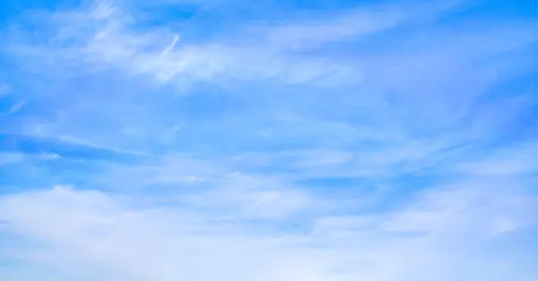 Parlak mavi gökyüzü, ince sirrus bulutları, soyut doğa arka planı.