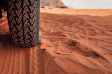 4wd araç lastiği, tozdan kirlenmiş - iz kırmızı kumda görünüyor, yakın plan detay