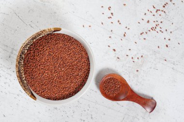 Cress (Lepidium sativum) tohumları küçük beyaz kâse içinde ahşap kaşık, yukarıdan görüş, bazıları masa gibi taşa saçılmış