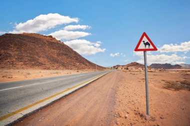 Wadi Rum 'da boş çöl yolu, kırmızı üçgen uyarı develeri