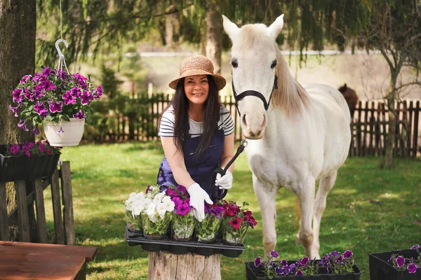 Žena Pracovním Oblečení Rukavice Slamák Pracovní Květinami Zahradě Bílý Kůň — Stock fotografie