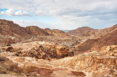 Ürdün, Feifa yakınlarındaki kayalık dağlar, yukarıdaki bulutlu gökyüzü, uzaktaki ölü deniz