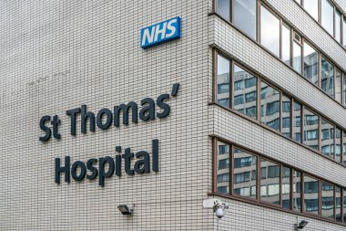 Londra, Birleşik Krallık - 2 Şubat 2019: Londra Köprüsü 'ndeki St. Thomas hastane duvarında NHS tabelası. Burası akademik sağlık bilim merkezi ve eğitim hastanesi.