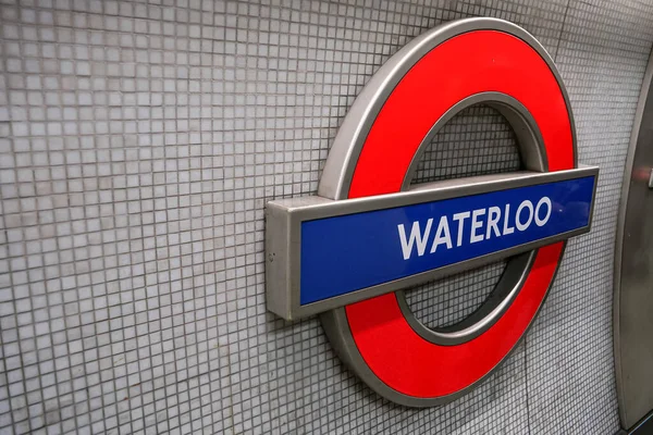 stock image London, United Kingdom - February 02, 2019: Waterloo underground station illuminated sign at wall of tube stop. Traditional red, white and blue design called roundel used since 1905