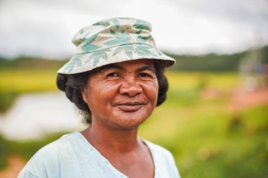 Ankarefo, Madagaskar - 25 Nisan 2019: Bilinmeyen Malagasy kadının portresi, bulanık yeşil alan arka planı. Madagaskar 'daki insanlar fakir ama neşelidir.