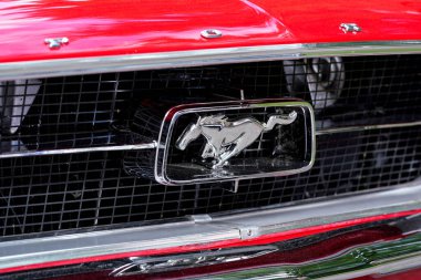 Liptovsky Hradok, Slovakya - 18 Haziran 2022: Klasik otomobil fuarında sergilenen kırmızı Ford Mustang arabasının önündeki gümüş at logosu ayrıntıları