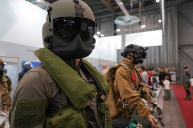 Kara vizör ve ceketli taktik askeri miğfer savunma silah sergisinde ve fuarda bir mankenin üzerinde..