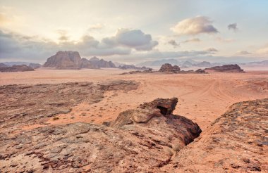 Kırmızı turuncu Mars, Ürdün Wadi Rum Çölü 'ndeki manzara gibi. Dağların arka planı, bulutlu bir sabah. Bu konum birçok bilim kurgu filminde kullanılmıştır..