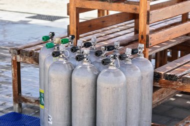 Plaj dalgıcı kulübesinde metal oksijen tüplü dalış tankı, yakın çekim detayı.