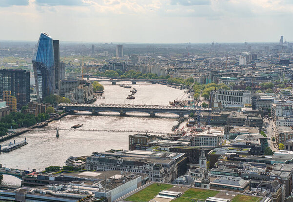 Aerial view of south west London on a sunny day, people walking over Millennium bridge, river Thames below.